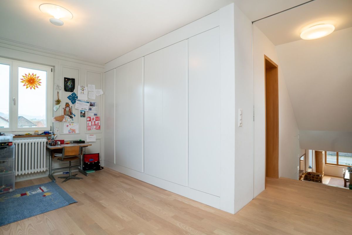 Helles Kinder- bzw. Arbeitszimmer mit Einbauschrank und Treppenabgang
