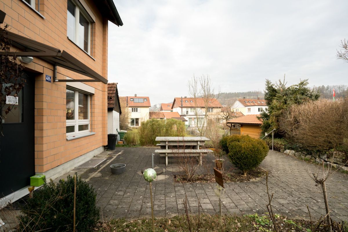 Haus mit gepflastertem Vorgarten und Blick in die Nachbarschaft