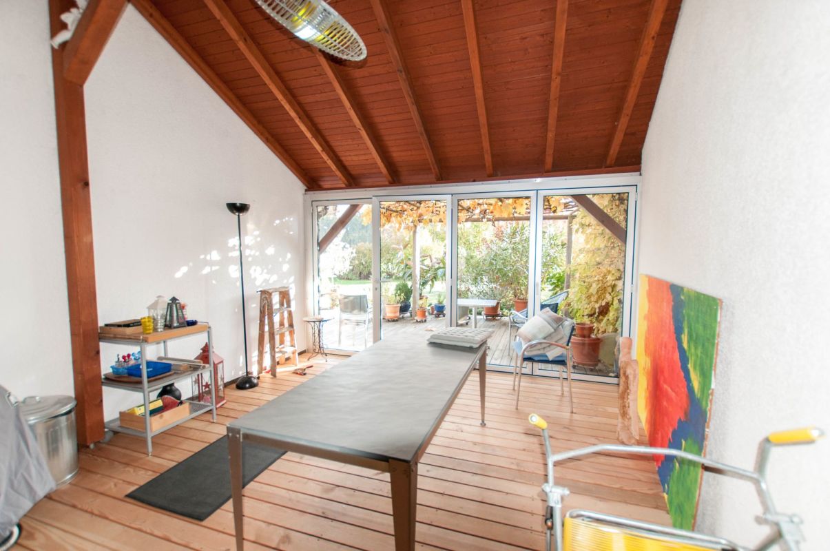 Überdachter Terrassenraum mit großem Tisch
