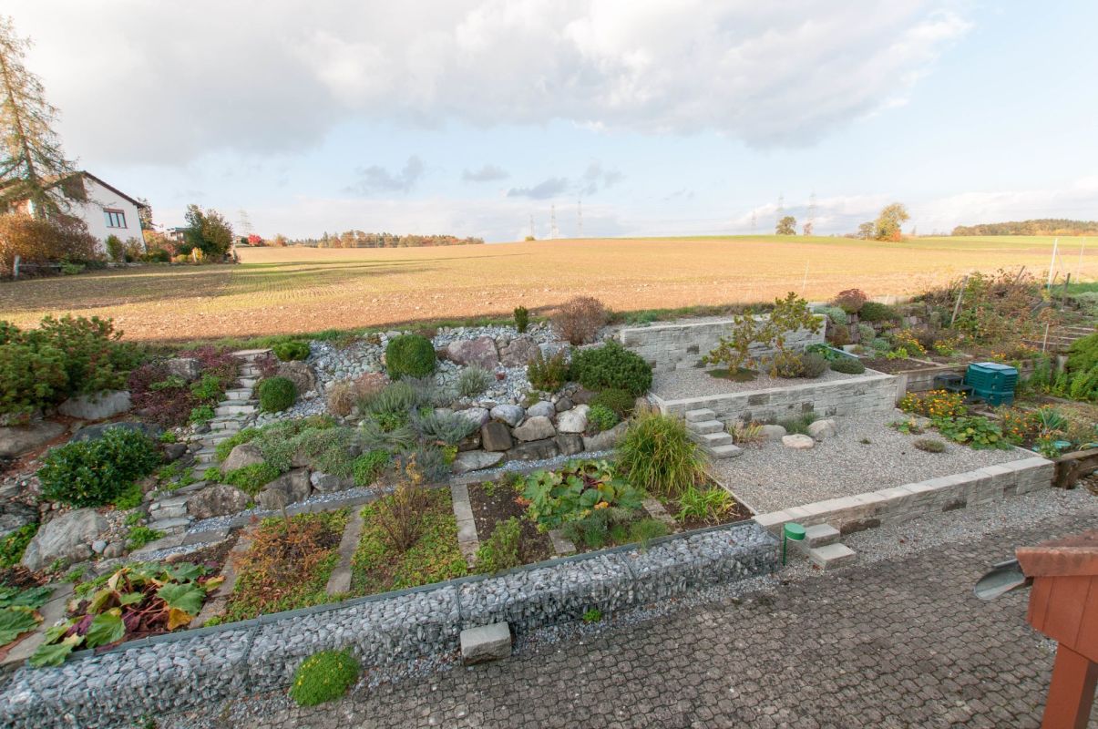 Weitläufiger Garten mit Trockenmauern und Feldblick
