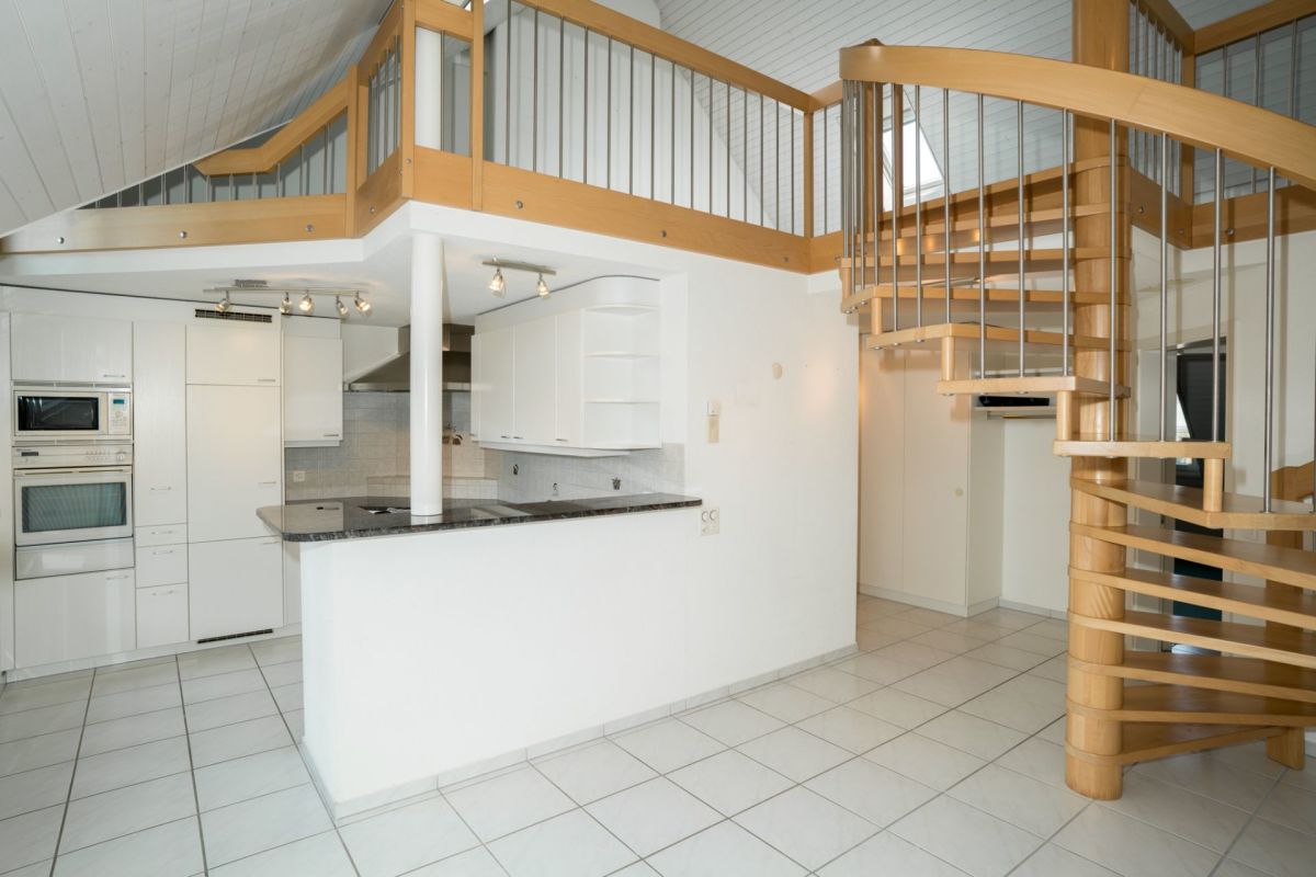Offener Wohnbereich mit Küche und Wendeltreppe