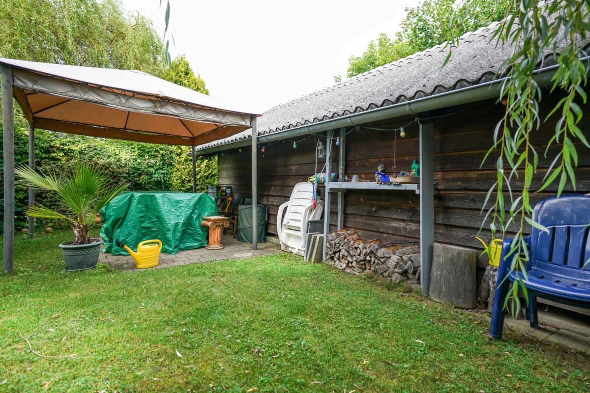 Garten mit überdachtem Sitz- und Stauraumbereich