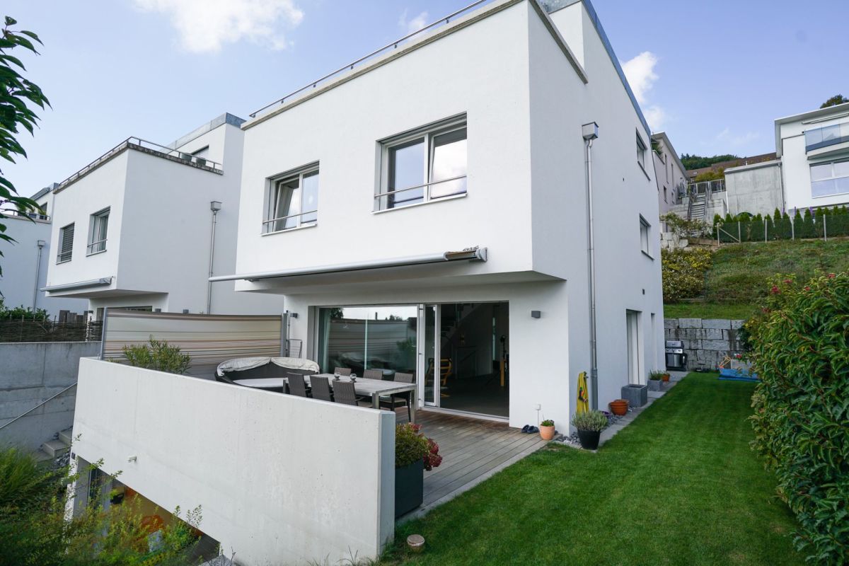 Moderne weiße Wohnhausfassade mit Garten und Terrasse