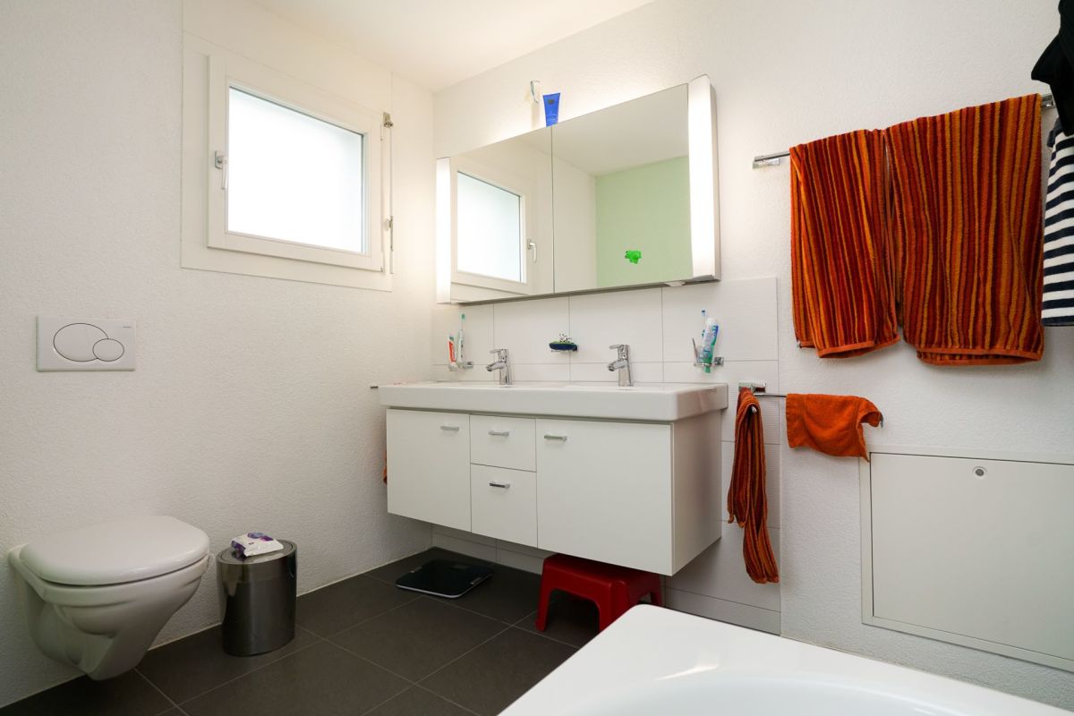 Helles Gäste-WC mit Waschtisch und Wandspiegel