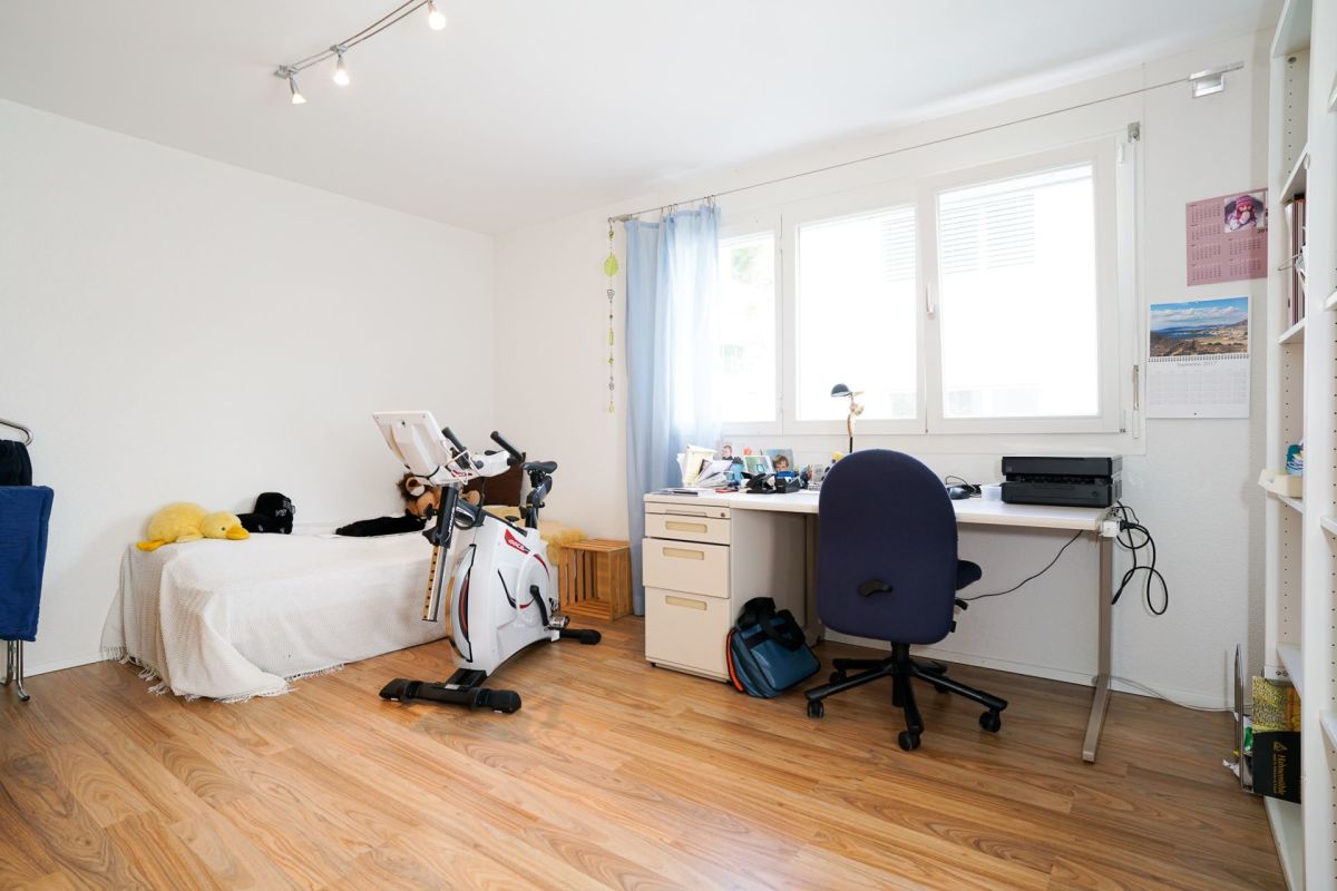 Helles Arbeits- und Schlafzimmer mit Trainingsrad