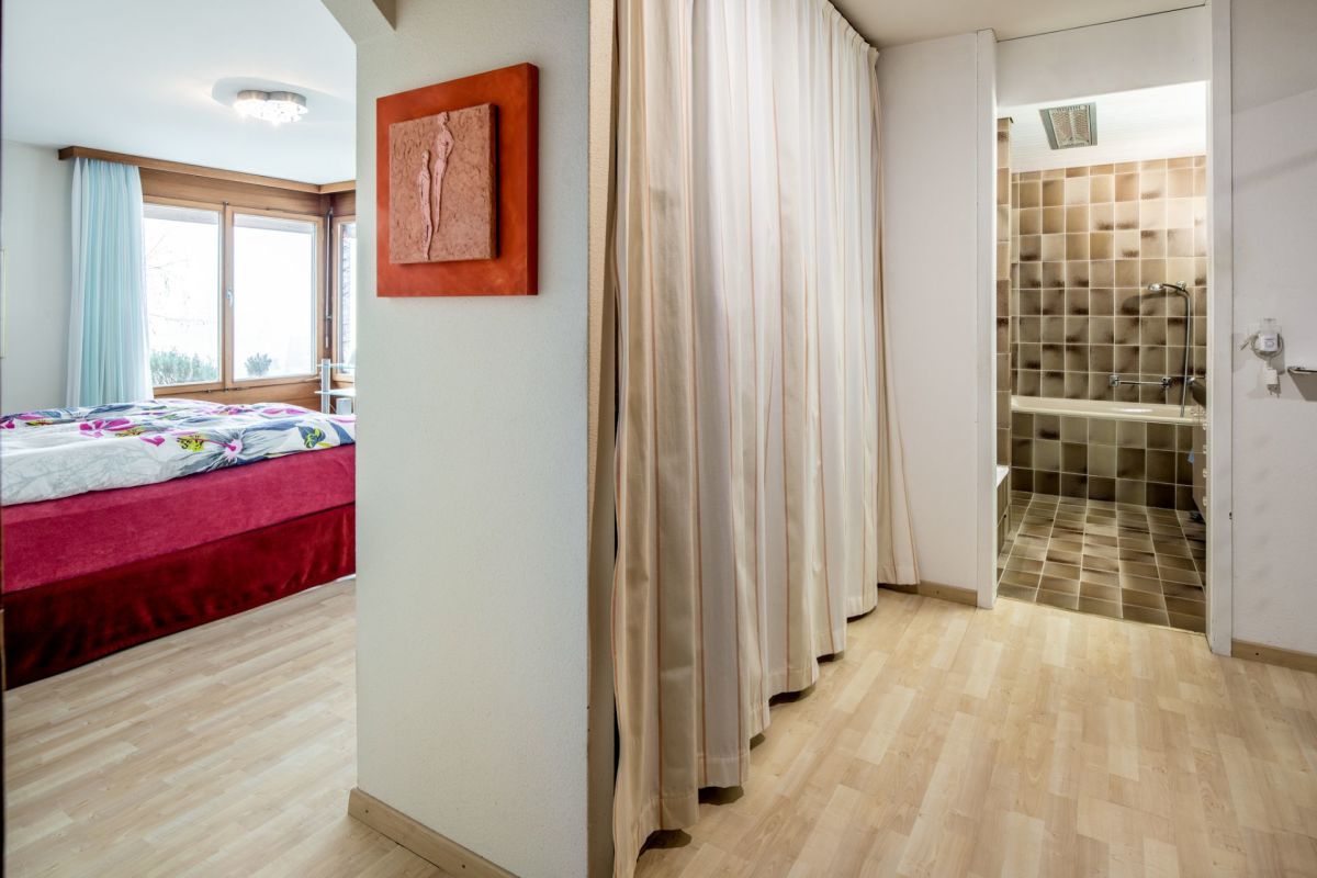 Schlafzimmer mit angrenzendem Bad und Vorhangabtrennung