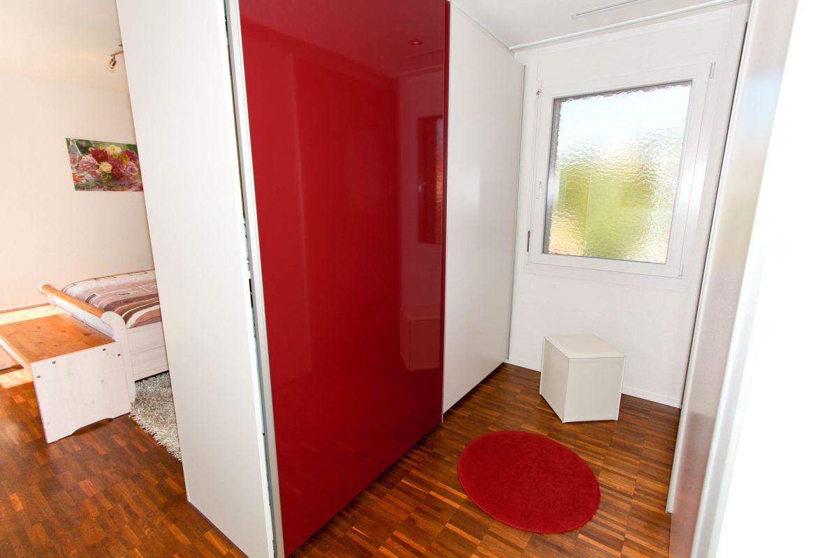 Helles Schlafzimmer mit rotem Schrank