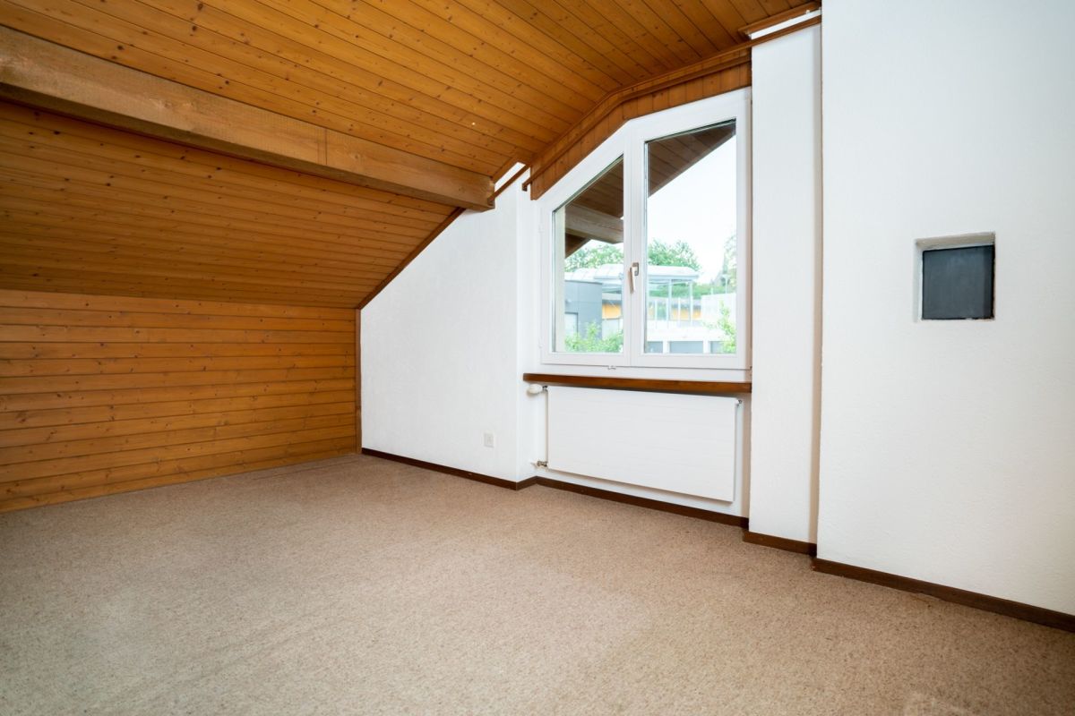 Dachgeschossraum mit Holzdecke und Teppichboden