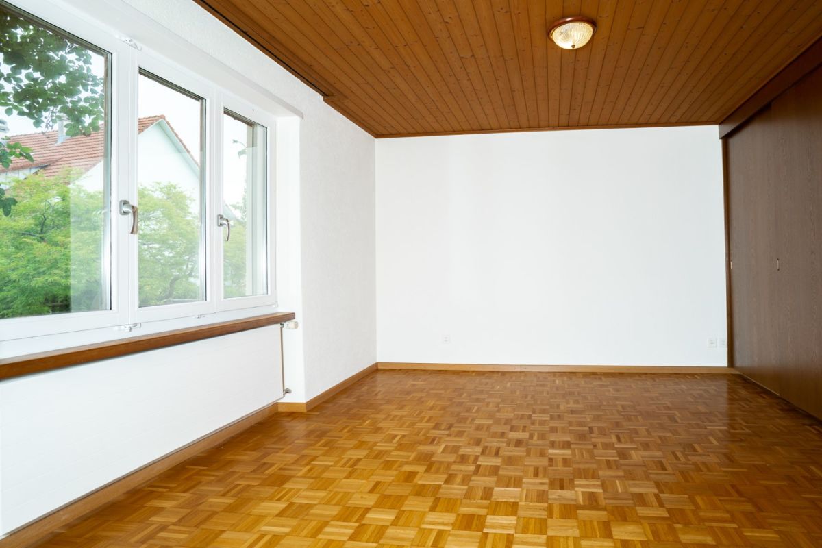 Leeres Zimmer mit Holzdecke und Parkettboden
