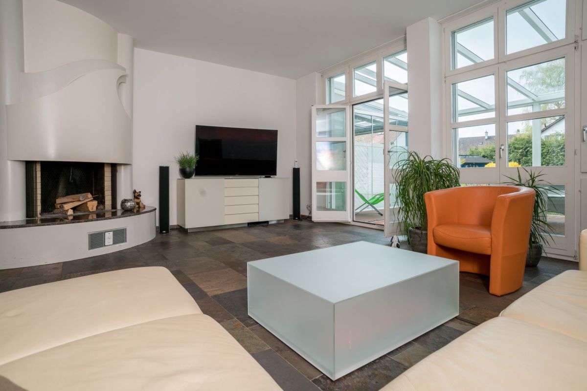 Modernes Wohnzimmer mit Kamin und Wintergarten