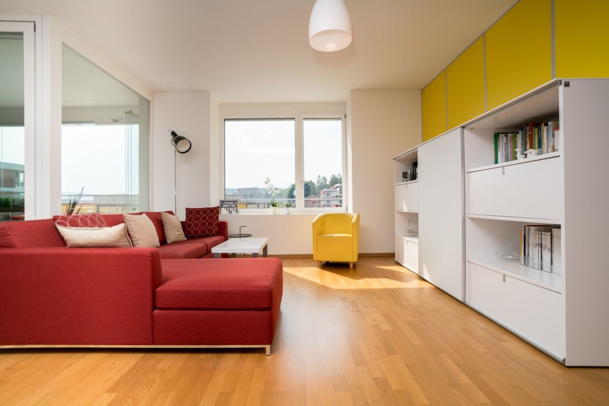 Helles Wohnzimmer mit rotem Sofa und gelbem Sessel