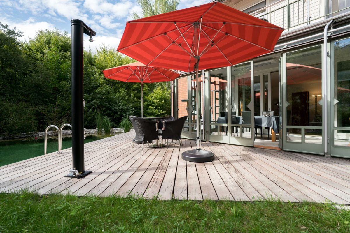 Terrasse am Haus mit roten Sonnenschirmen
