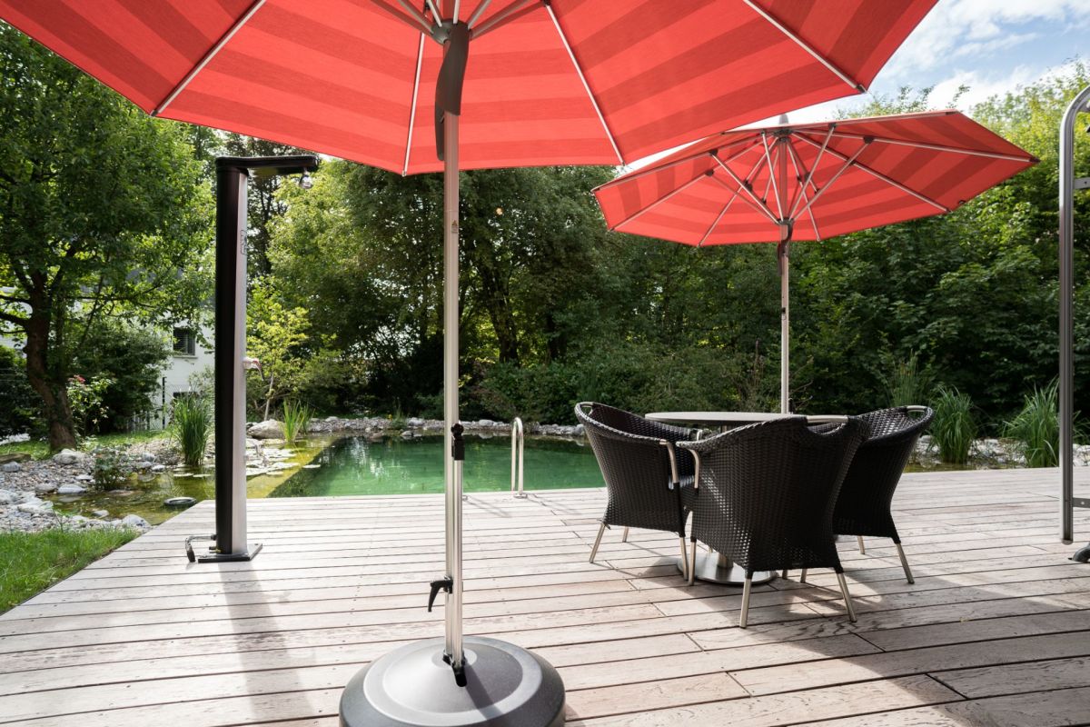 Terrasse am Pool mit roten Sonnenschirmen
