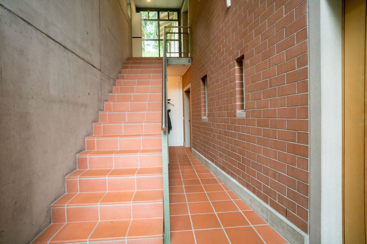 Treppenhaus mit Ziegelwand und Terrakotta-Fliesen