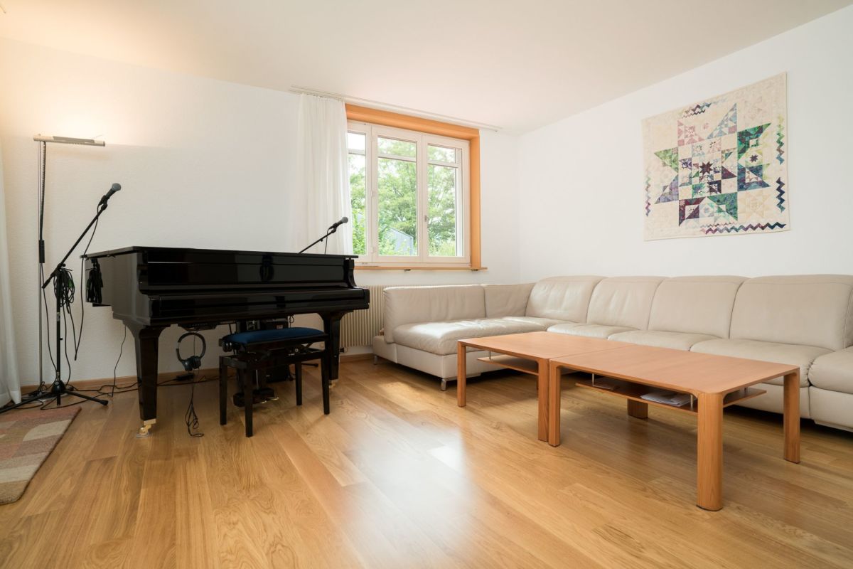Wohnzimmer mit Flügel und Sofa