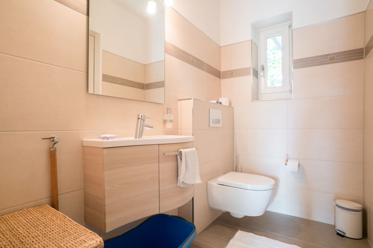 Modernes Gäste-WC mit hellem Waschtisch und Wand-WC
