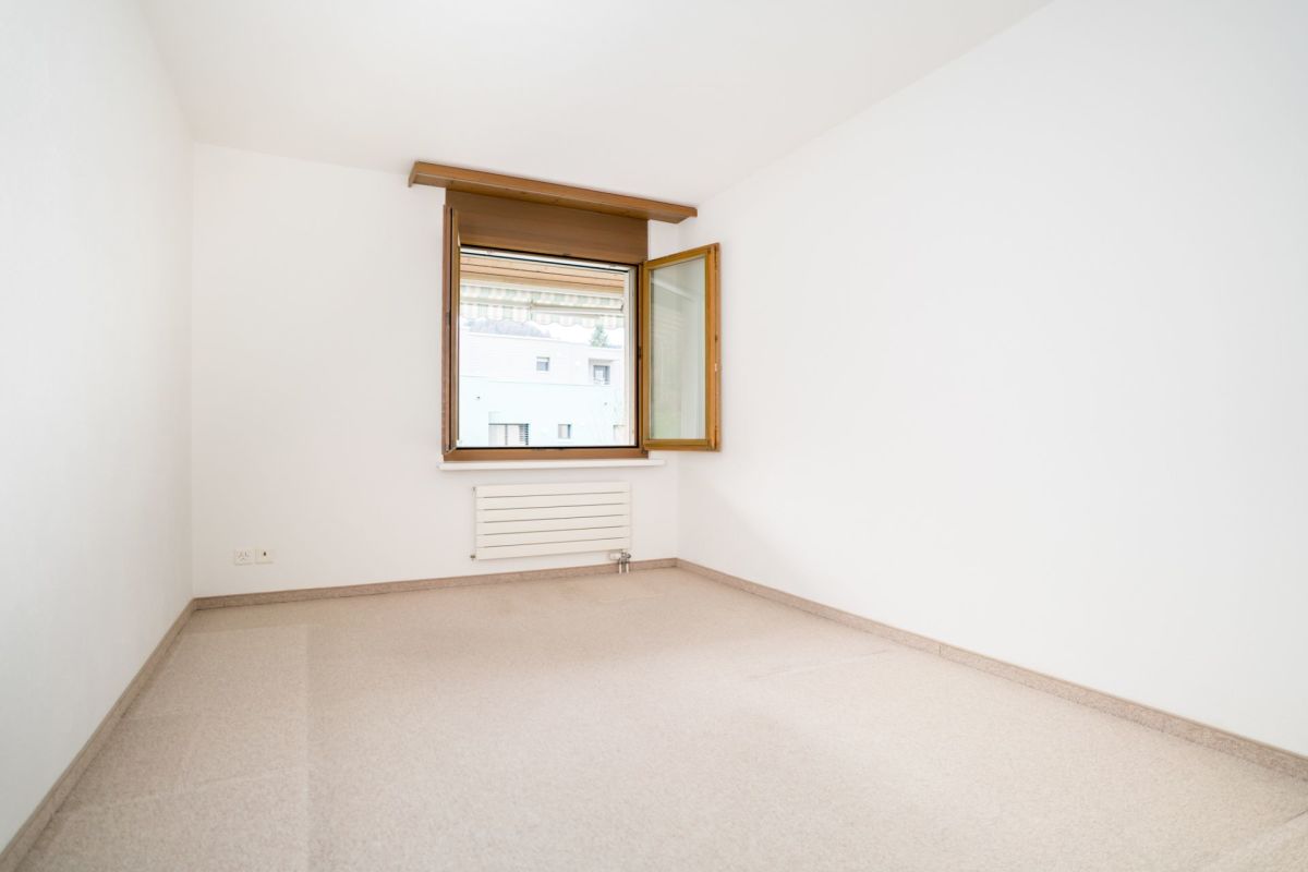 Leerer heller Raum mit Holzfenster und Heizkörper