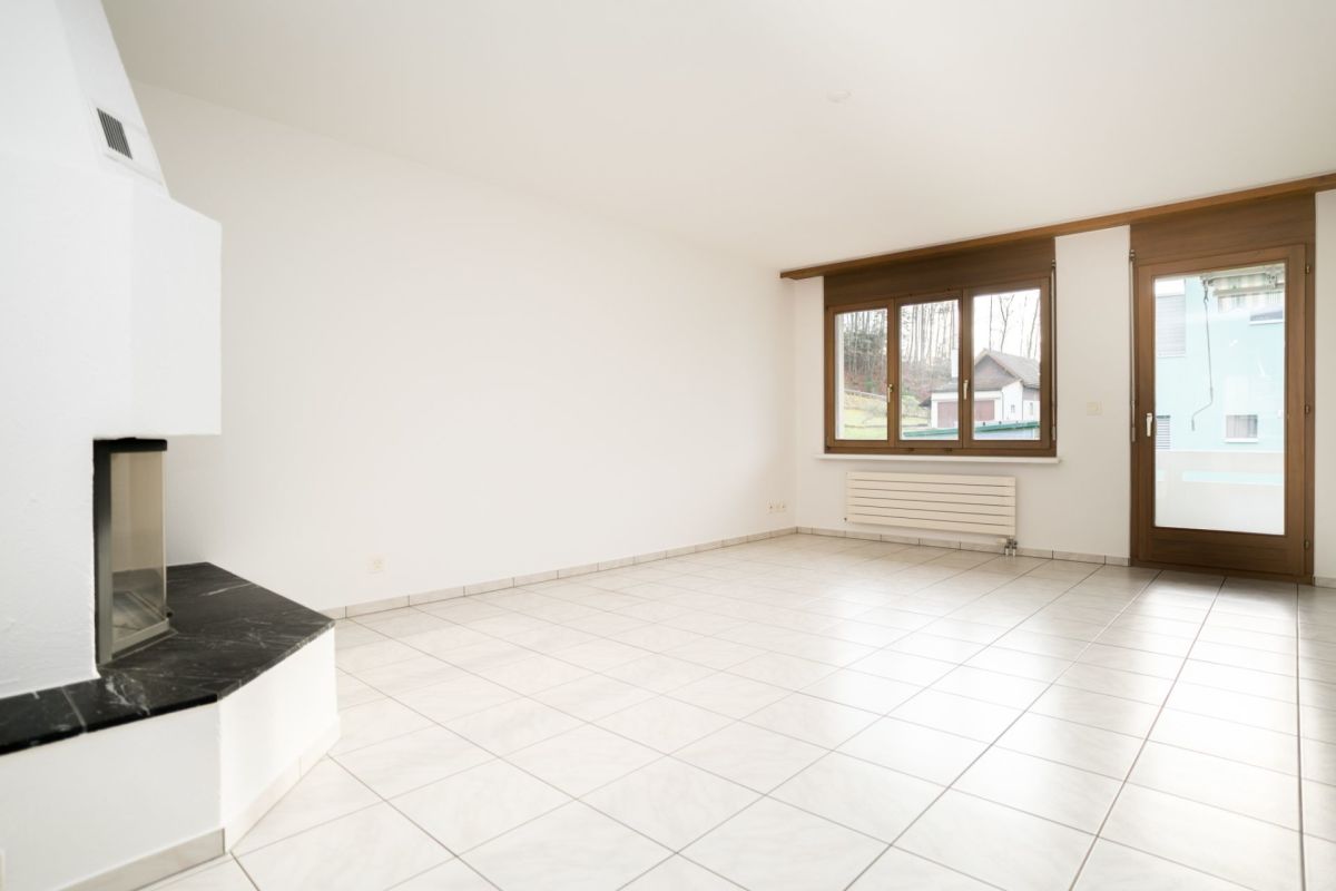 Heller Wohnraum mit Kamin und großem Fenster