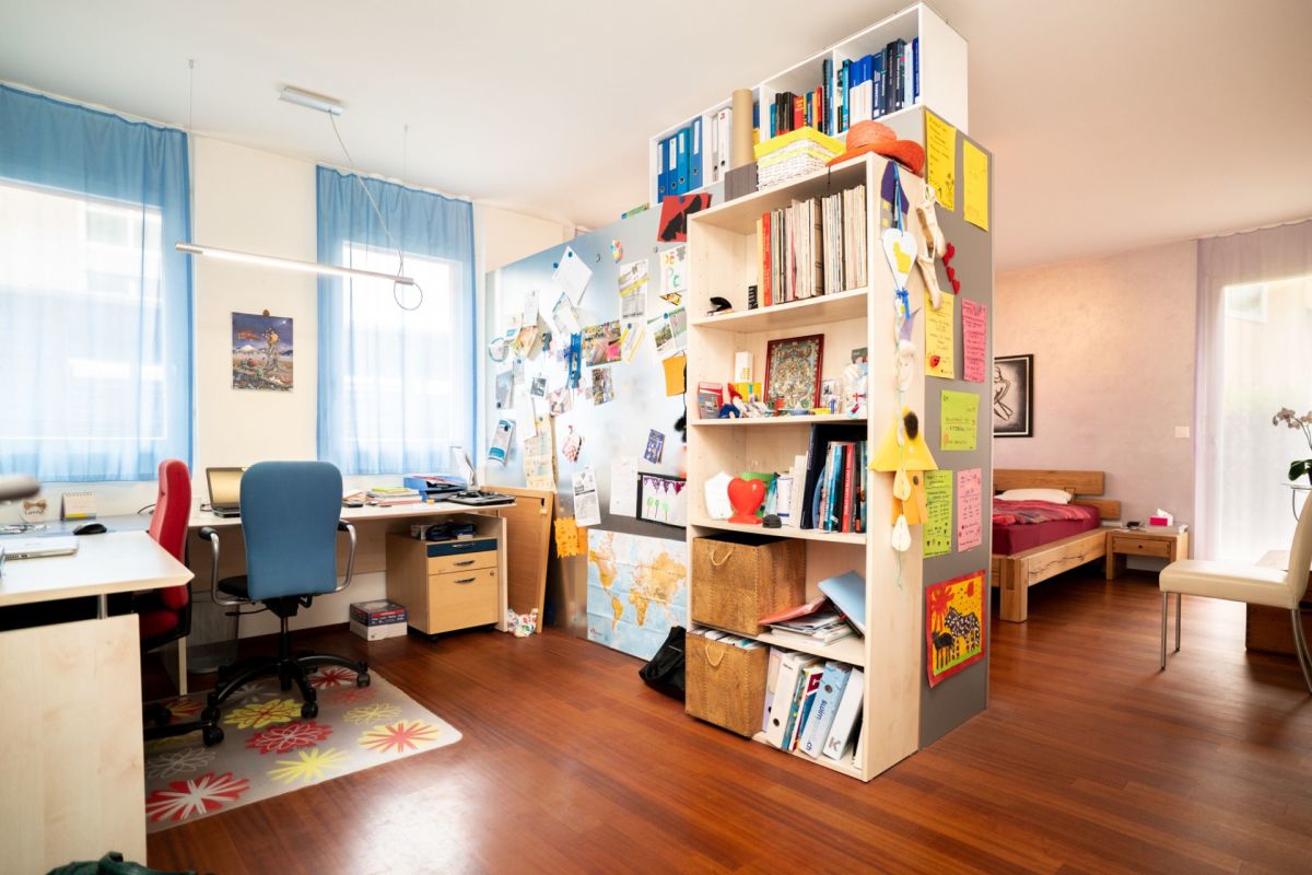Arbeits- und Schlafzimmer mit Regalen