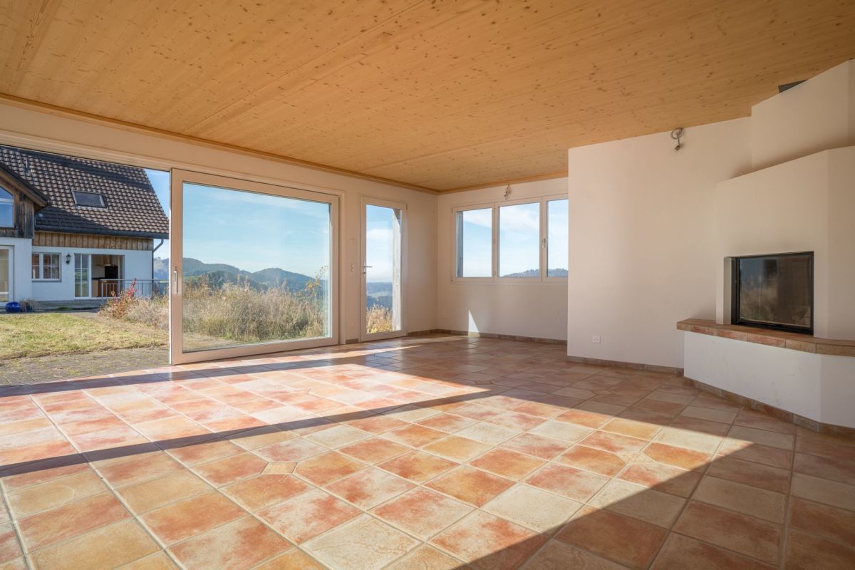 Großer Wohnraum mit Terrakottafliesen und Kamin