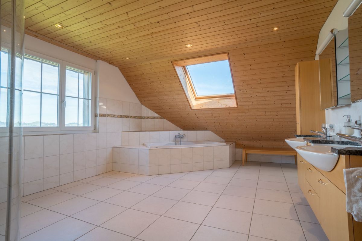 Badezimmer mit Holzdecke und Badewanne