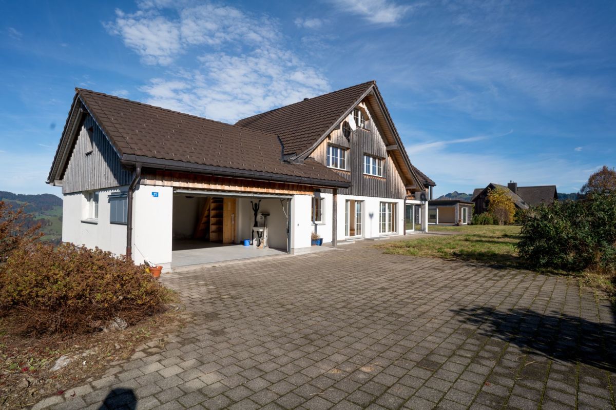 Außenansicht eines Landhauses mit Carport und großer Zufahrt