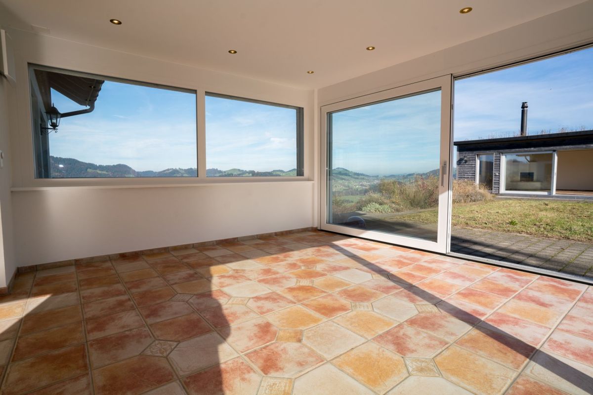Heller Raum mit großer Verglasung und Terrassenausgang