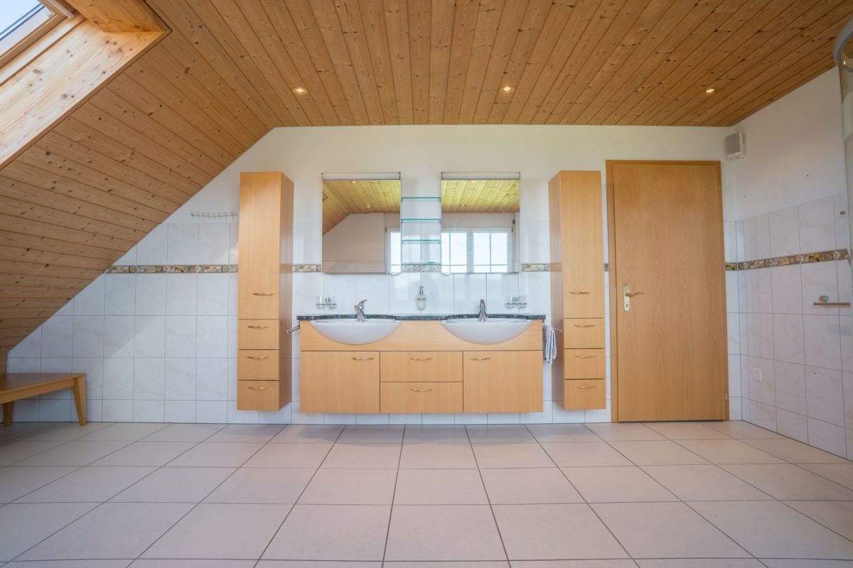 Badezimmer mit Holzdecke und Doppelwaschtisch