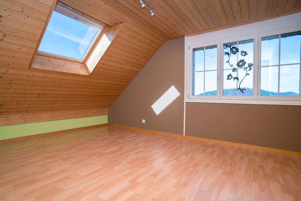 Dachzimmer mit Dachfenster und Holzverkleidung