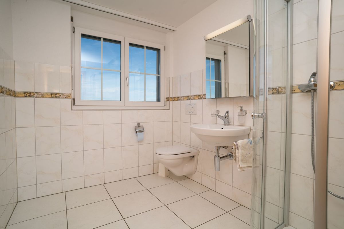 Helles Badezimmer mit Dusche und Fenster