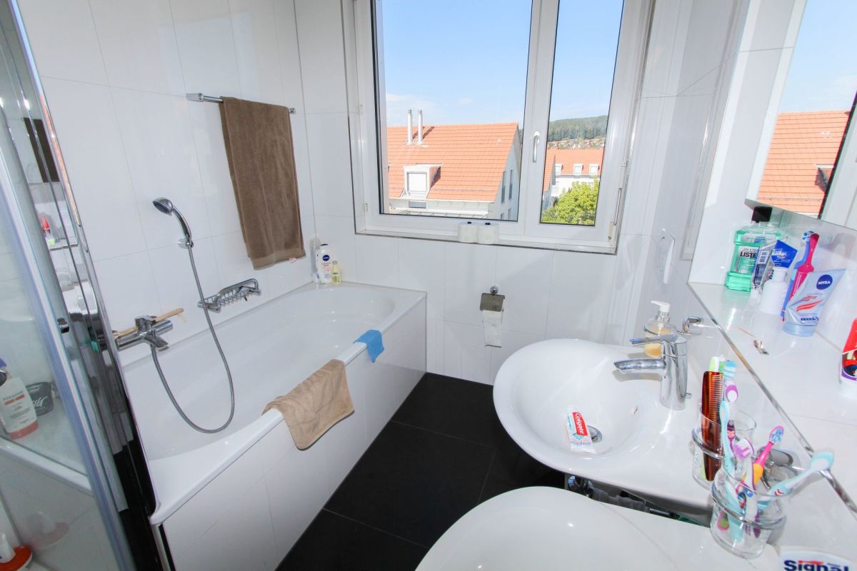 Modernes Badezimmer mit Badewanne und Fensterblick