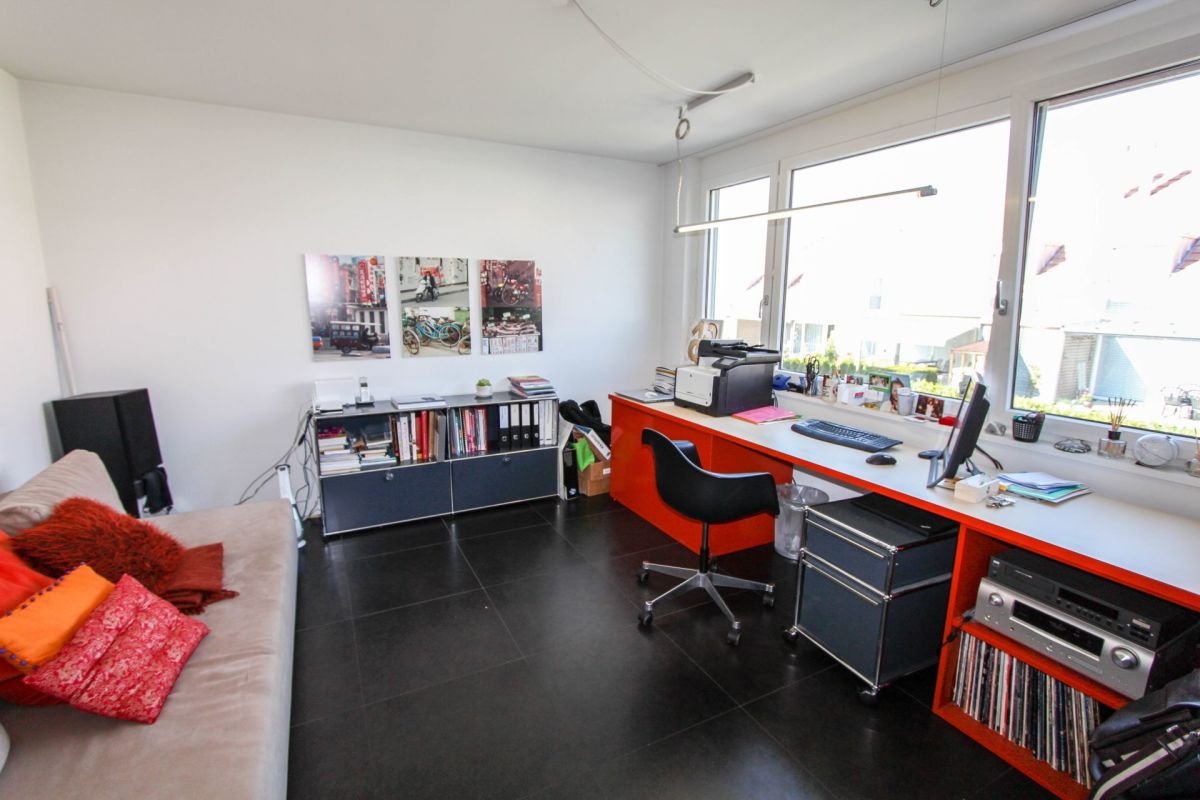 Helles Arbeits- bzw. Wohnzimmer mit großem Fensterbereich