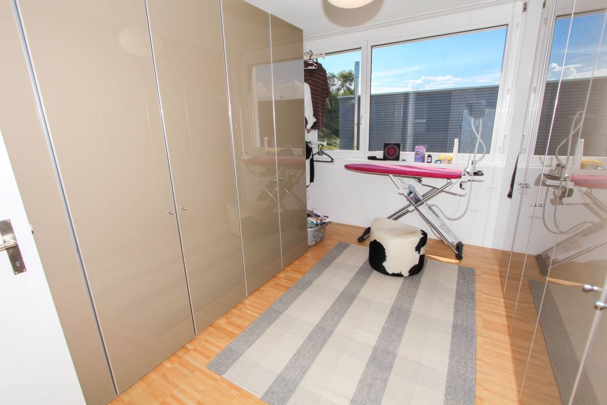 Helles Ankleidezimmer mit Bügelbereich