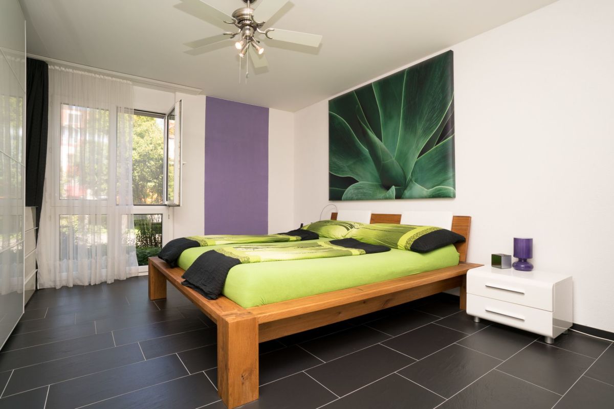 Modernes Schlafzimmer mit großem Bett und dunklem Boden