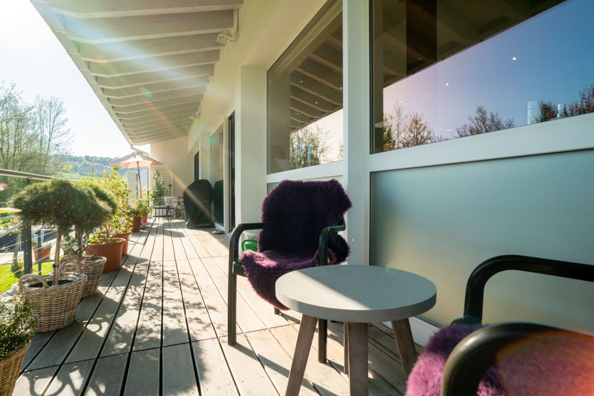 Sonnige Terrasse mit Möbeln und Pflanzen