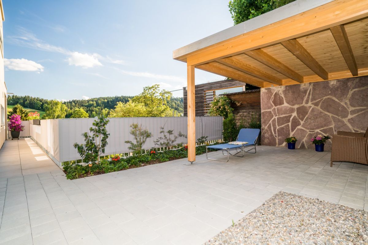 Überdachte Terrasse mit Gartenblick