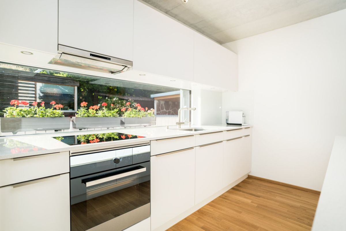 Moderne weiße Küche mit Fensterfront