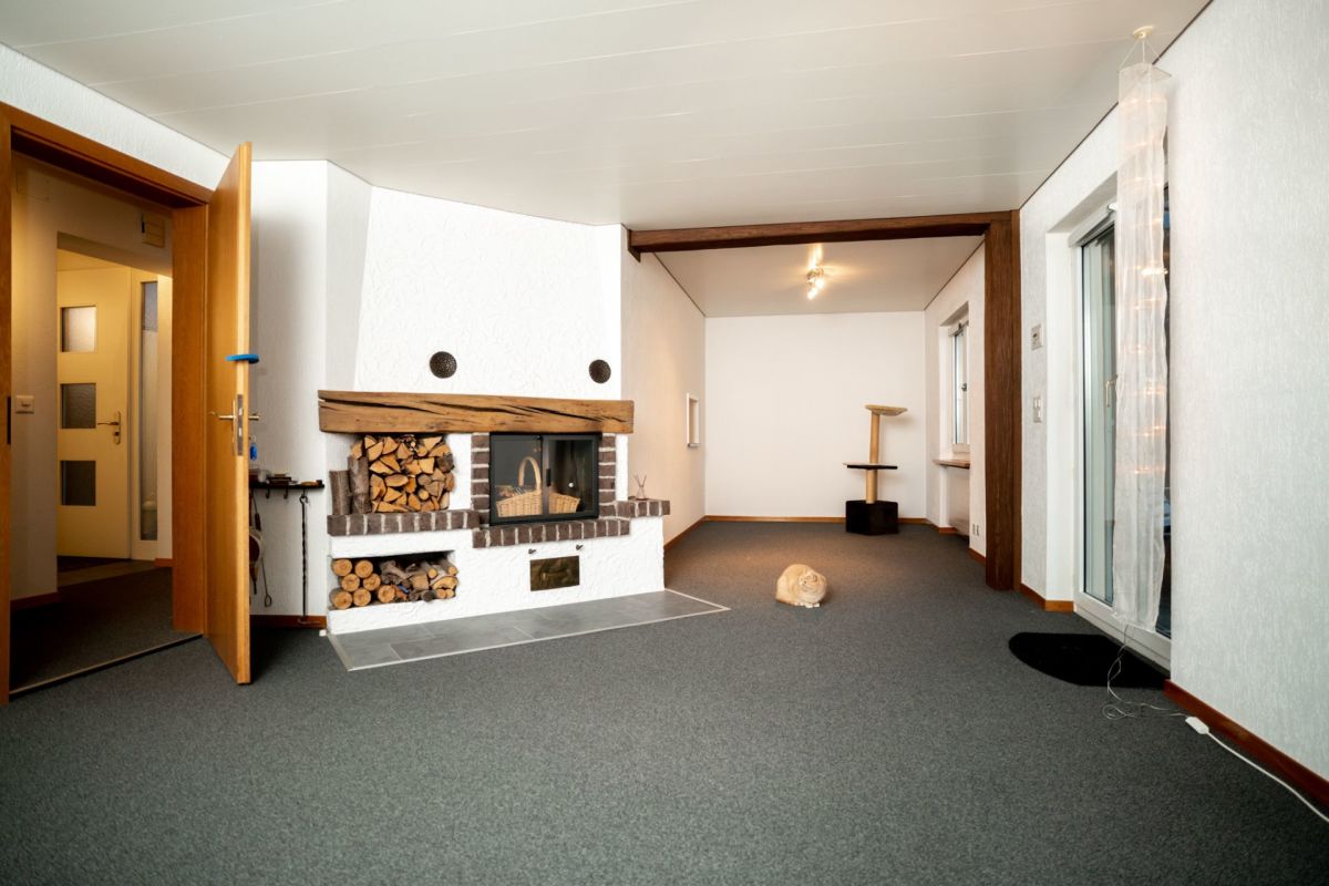 Wohnraum mit Kamin und Zugang zum Balkon