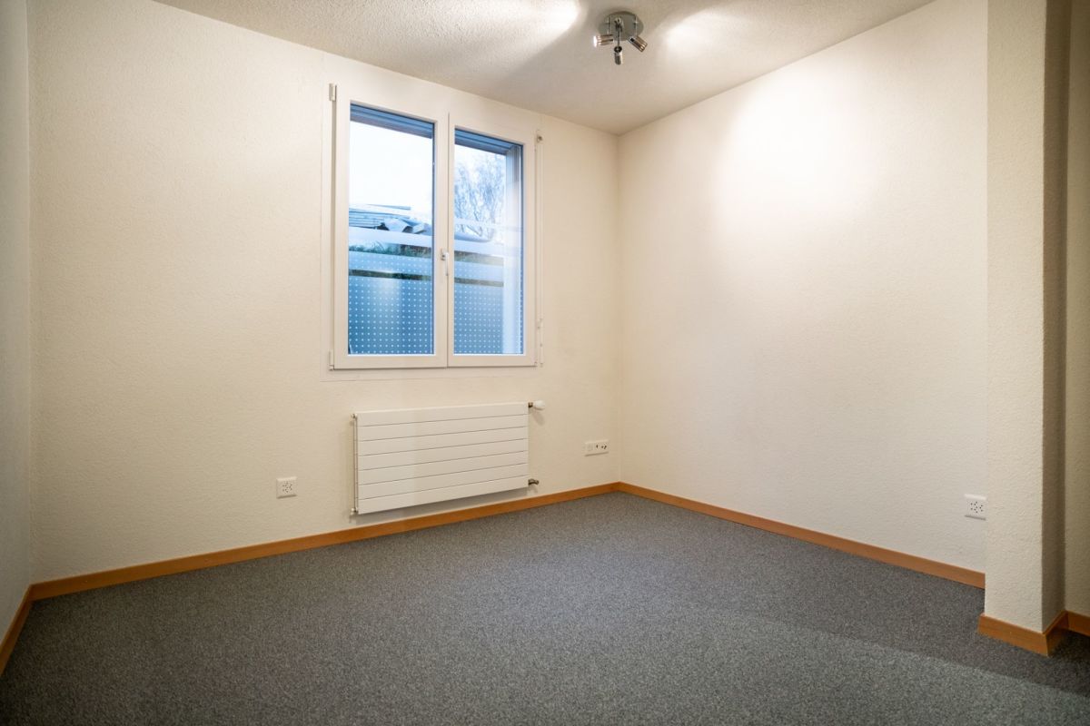 Leerer, heller Innenraum mit Fenster und Heizung