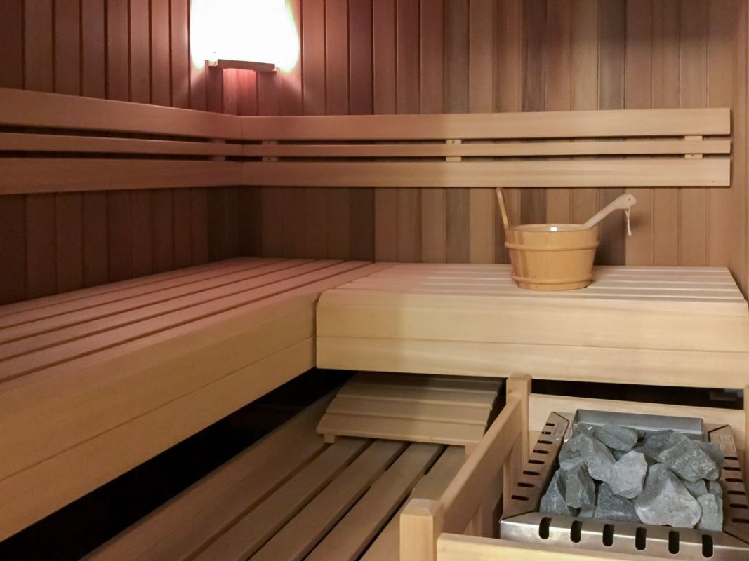 Sauna-Innenraum mit Holzbank und Ofen