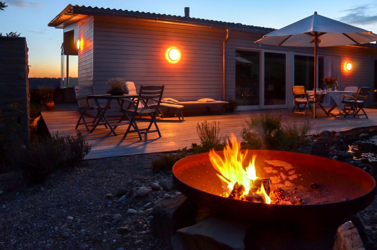 Terrasse mit Feuerstelle bei Dämmerung