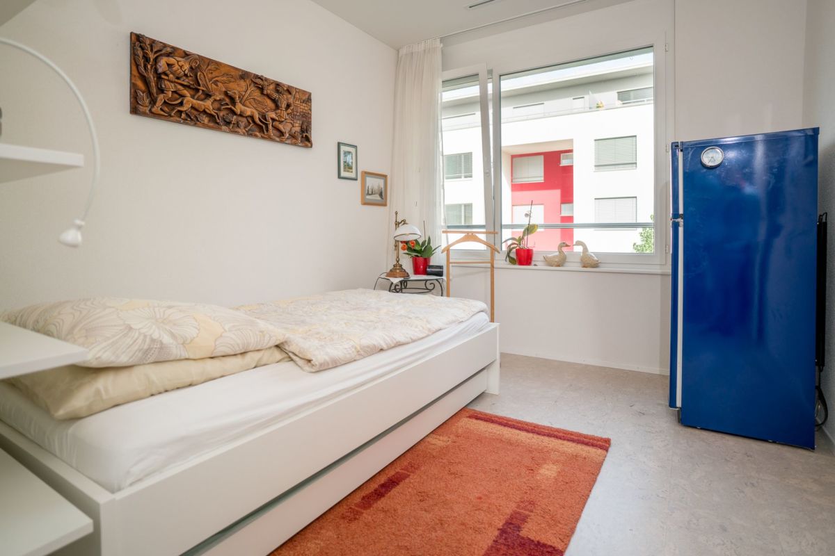 Helles Schlafzimmer mit Einzelbett und Fensterblick