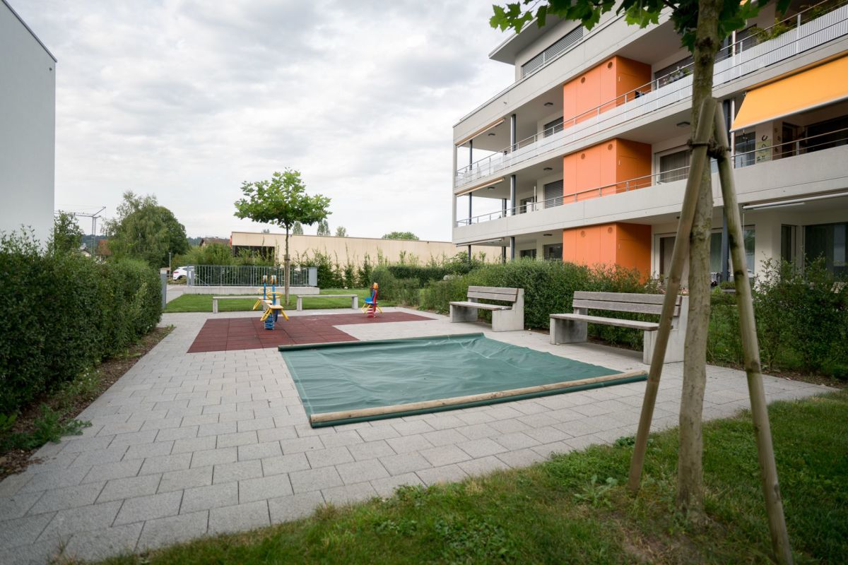 Gemeinschaftlicher Außenbereich mit Spielplatz und Sitzbänken