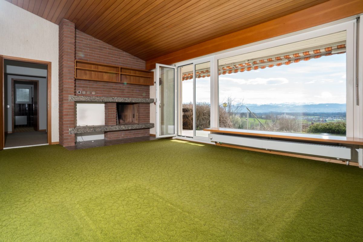 Wohnzimmer mit Kamin und Panoramafenster