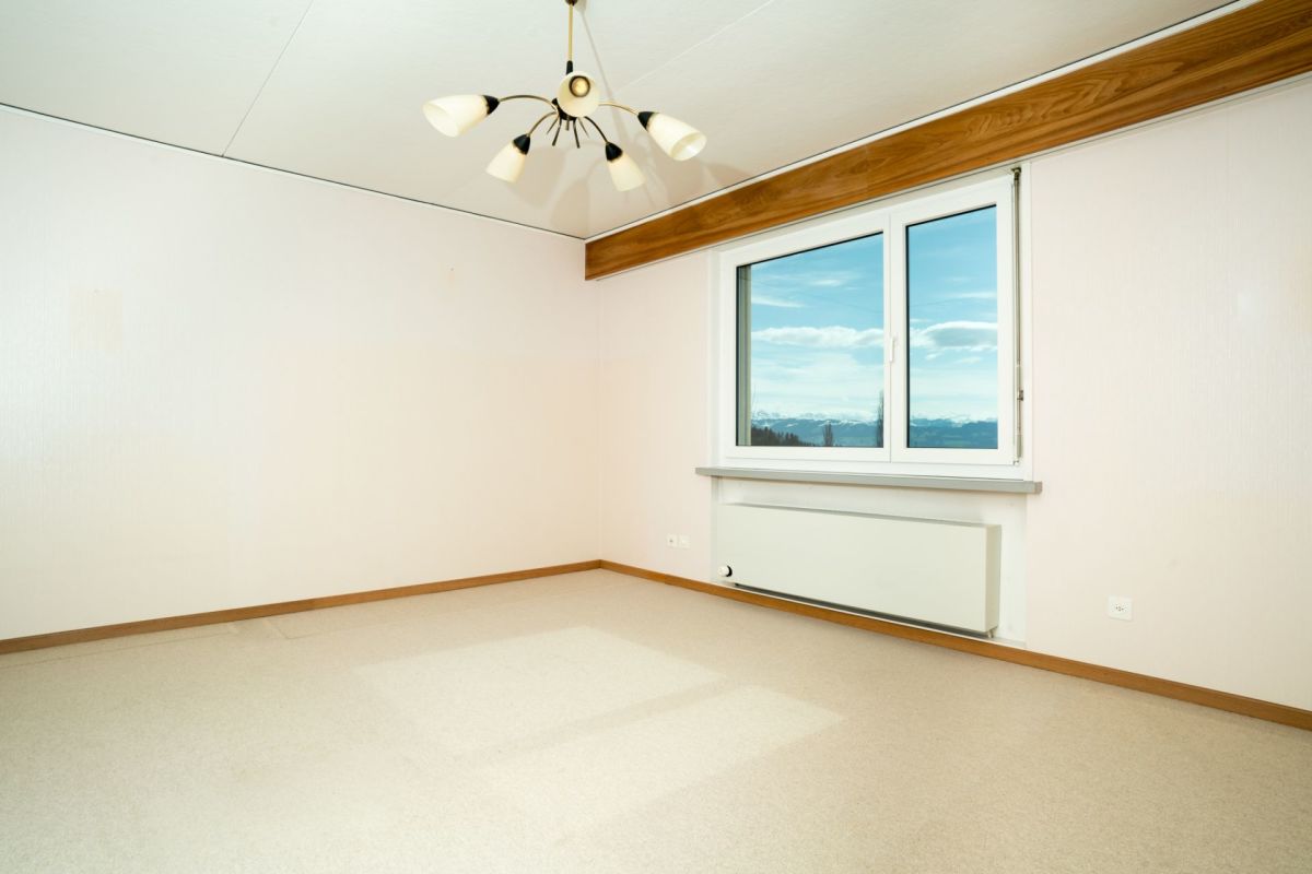 Leerer, heller Raum mit Fenster und Heizung
