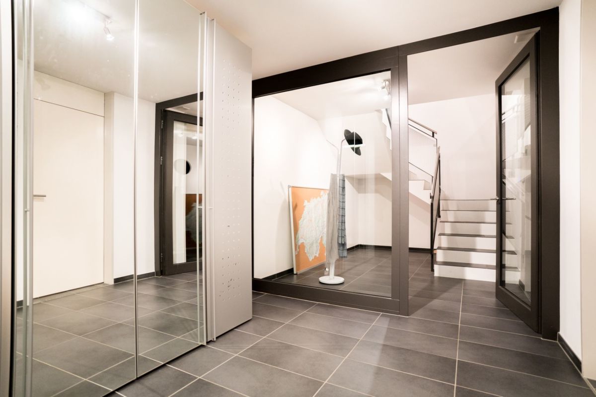 Moderner Eingangsbereich mit Treppe und Spiegeln