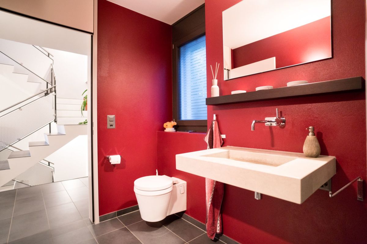 Modernes Gäste-WC mit Treppe im Hintergrund