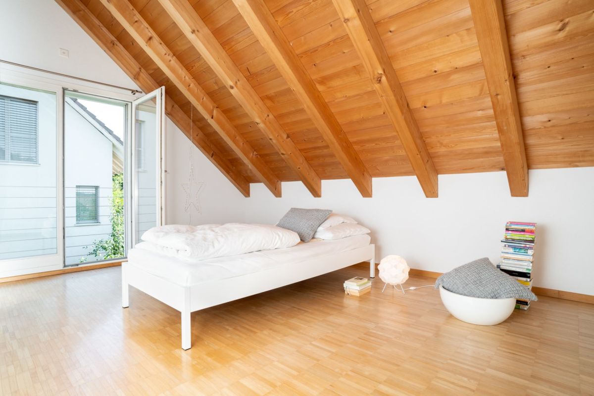 Helles Dachgeschoss-Schlafzimmer mit Holzbalkendecke