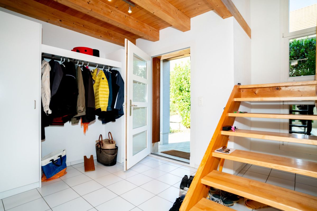 Heller Eingangsbereich mit Holztreppe