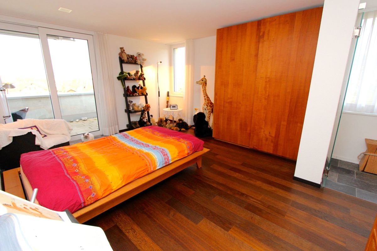 Schlafzimmer mit Balkonzugang und Holzschrankwand